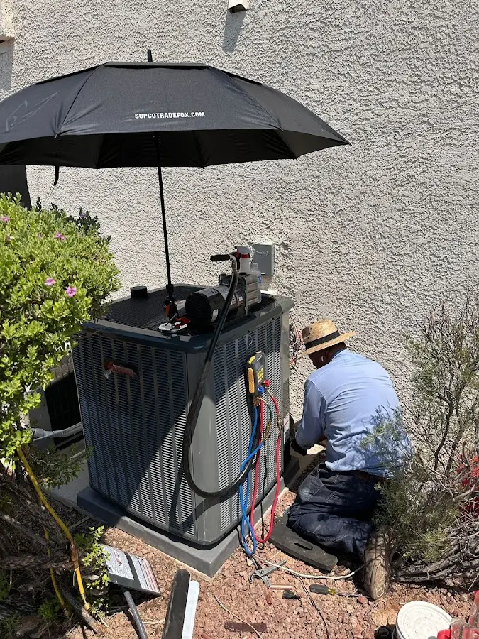 HVAC technician performing outdoor AC maintenance in Belmont